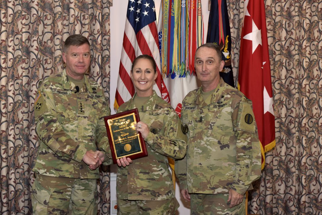 Staff Sgt. Nicole Bourgeois, 2016 TRADOC National Guard Instructor of the Year, 1st Battalion (Noncommissioned Officer Academy), 199th Regiment Regional Training Institute at Camp Cook in Ball, Louisiana, receives a plaque and congratulations from Gen. David Perkins, commanding general of U.S. Army Training and Doctrine Command, and Command Sgt. Maj. David Davenport, TRADOC senior enlisted leader, during the 2016 TRADOC Instructor of the Year ceremony at the Fort Eustis Club in Virginia, Aug. 3, 2017. (U.S. Army photo by Angel Clemons)