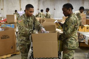 Louisiana Army Guard Soldiers pack non-perishable food boxes for the Greater Baton Rouge Food Bank in Baton Rouge, Louisiana, March 22, 2020. Soldiers are assisting the food bank to ensure the supply of food for the needy is maintained during the increased demand from COVID-19. (U.S. Air National Guard photo by Master Sgt. Toby M. Valadie)